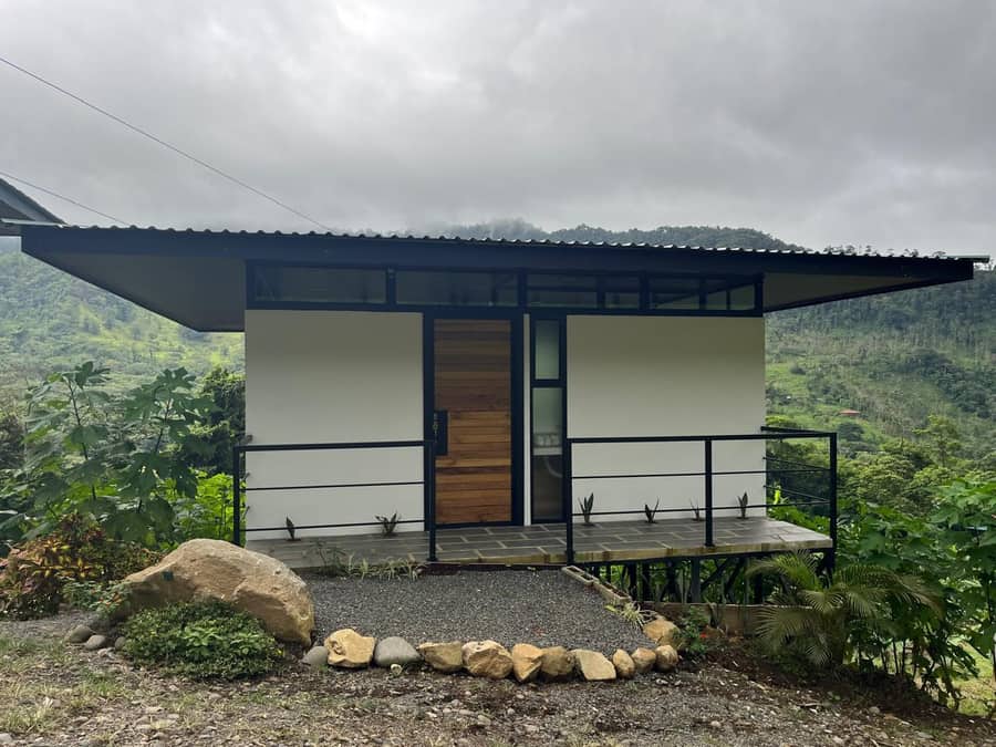 Exterior de una cabaña moderna de madera y estuco entre la naturaleza